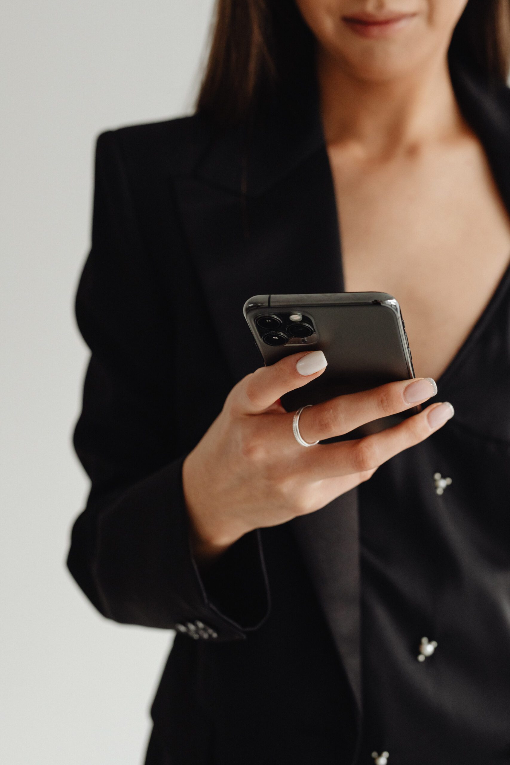 kaboompics_dark-classy-aesthetic-fashion-beautiful-asian-female-entrepreneur-in-black-suit-technology-and-devices-iphone-laptop-airpods-30088